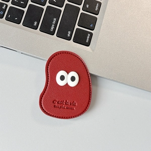 Macro detail of red faux leather phone grip with cute eyes and C'est la vie embossing