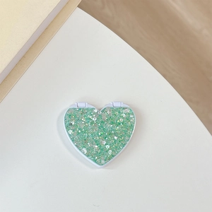 Close-up of heart-shaped folding mirror with mint green glitter and sequins finish