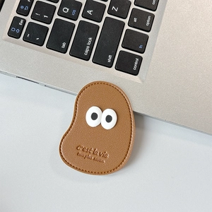 Detailed view of brown lychee leather phone stand with cute eyes and engraved text