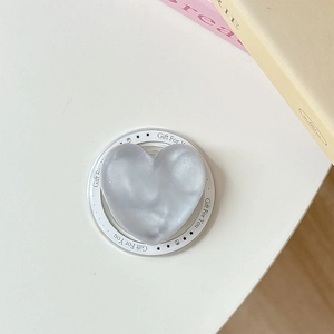 Detail of grey heart-shaped phone grip with Gift For You text on a white base