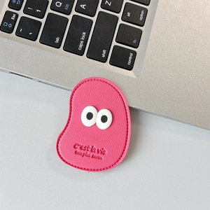 Pink lychee texture leather phone grip featuring cute 3D big eyes design on a laptop