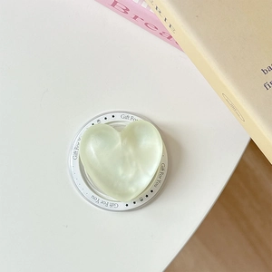Detail of light green glitter heart phone socket with Gift For You print on white surface