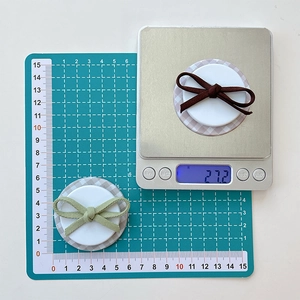 Bow phone grip dimensions and weight showing diameter on a green cutting mat