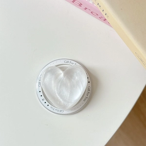 Macro shot of pearl white heart magnetic phone grip with Gift For You typography