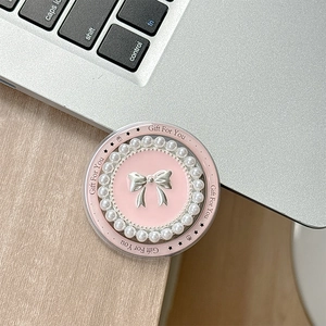 Détail du support de téléphone rose avec nœud argenté et perles sur ordinateur