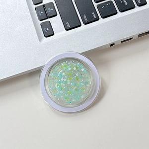 Detail of a round clear phone socket featuring colorful mint and yellow glitter sequins