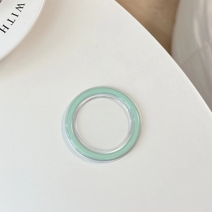 Macro detail of a minimalist mint green Magsafe phone socket base with a clear outer ring