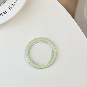 Close-up of a light green MagSafe magnetic phone ring holder on a white ceramic tray