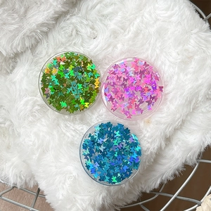 Three sequin butterfly phone grips in green, pink and blue on white plush background