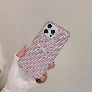 Detail of pink rhinestones and a silver crystal bow on the luxury iPhone case