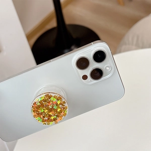 Detailed view of a round phone grip with shimmering butterfly sequins on a white smartphone