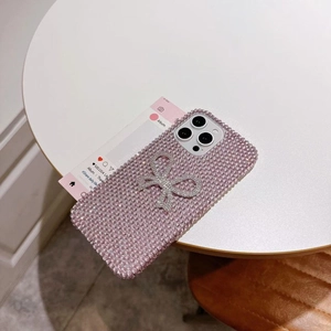 Detail of luxury pink rhinestone phone case with a silver bow for iPhone models