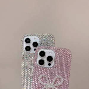 Detail of luxury rhinestone iPhone cases featuring sparkling 3D bows in silver and pink