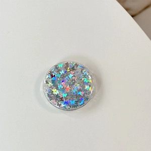 Close-up of a round phone socket with colorful holographic butterfly sequins inside