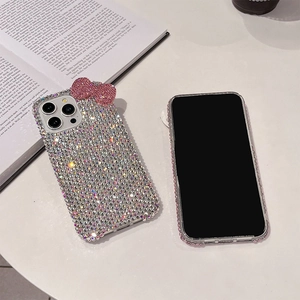 Macro detail of luxury iPhone case featuring silver rhinestones and pink crystal bow