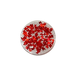 Sparkling red butterfly sequins for nail art in a round clear jar, perfect for DIY crafts
