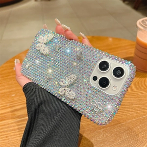 Vue détaillée de la coque iPhone ornée de strass colorés et de papillons en perles blanches