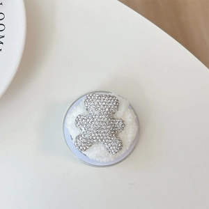 Macro shot of rhinestone bear phone grip with soft plush base on white background