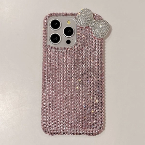 Close-up of pink crystal bow phone case for iPhone Pro Max with glittering rhinestones