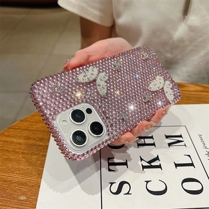 Détail de coque iPhone de luxe ornée de strass roses et d'un papillon argenté en 3D