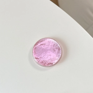 Macro shot of a pink round phone grip with metallic foil texture and clear resin dome coating