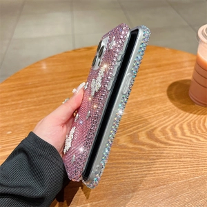 Détail de la coque iPhone en strass rose avec papillons 3D et bordures étincelantes