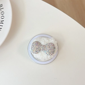 Close-up of sparkling AB rhinestone bow on plush base for heart bear phone grip accessory