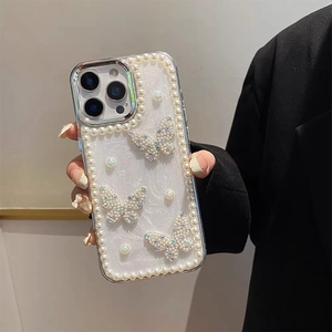 Close-up of iPhone clear case featuring white pearls and rhinestone butterfly decorations