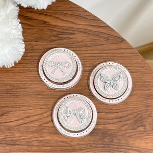 Pink magnetic rhinestone bow phone grip set with leather texture on wood surface