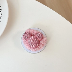 Detailed view of a pink plush phone grip featuring a sparkling rhinestone mouse icon