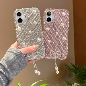 Coque iPhone luxe avec strass, perles et pompon nœud papillon, affichée en deux couleurs