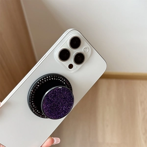 Macro shot of purple glitter MagSafe phone grip with black rhinestone border on device