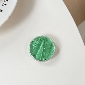 Macro detail of round light green phone grip with silver foil and vertical textures