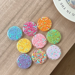 Set of 8 round resin phone socket grips with colorful heart sequins on a wood surface