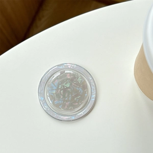 Detail of round shell texture phone grip with iridescent pearl fragments and clear resin edge