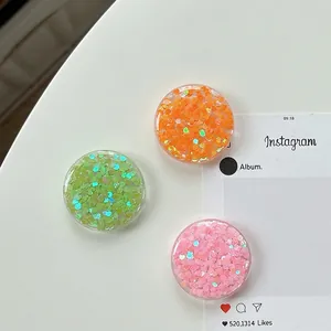 Set of three round griptoks with colorful heart sequins in pink, green and orange