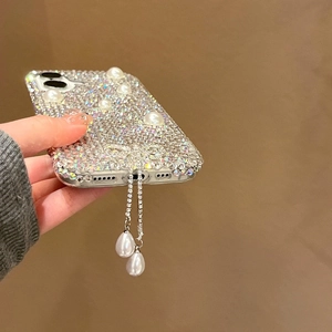 Vue détaillée de la coque iPhone de luxe avec pompons en strass et perles blanches décoratives