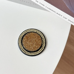 Detail of a round MagSafe phone stand with gold glitter and double rows of rhinestones