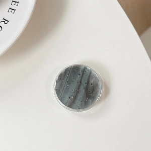 Macro view of round grip tok with grey marble pattern and silver glitter foil detailing