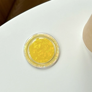 Detail of yellow round phone grip with crystal cut texture and pearl luster finish