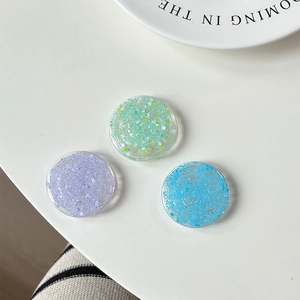 Vue détaillée de supports ronds scintillants pour téléphone en violet vert et bleu