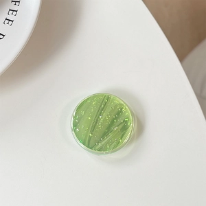 Detail shot of round green phone socket with gold foil sparkles and resin finish