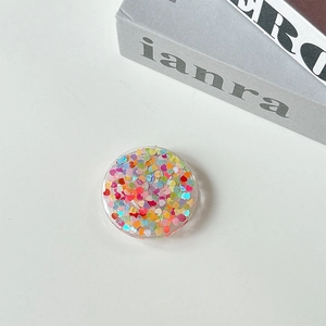 Detailed macro view of heart-shaped colorful sequins inside a clear phone socket grip