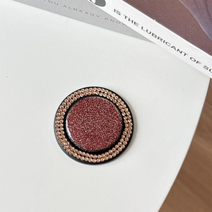 Detail of round MagSafe phone grip with dark reddish brown glitter and sparkling rhinestones