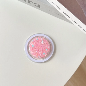 Detail of pink heart-shaped sequins inside a transparent MagSafe phone grip