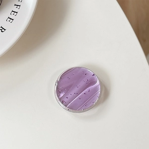 Detail view of round purple marble phone grip with silver flakes and glossy resin finish