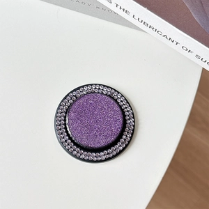 Close-up of a round purple glitter MagSafe phone grip with sparkling crystal rhinestone edges
