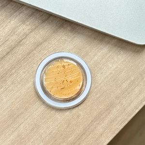Dettaglio del supporto MagSafe con motivo a foglia d'oro su scrivania in legno