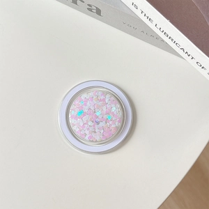 Detail of a round MagSafe phone socket filled with sparkly pink and white heart sequins