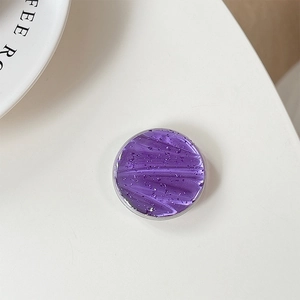 Detail of round purple resin phone grip with glitter and fluid art texture